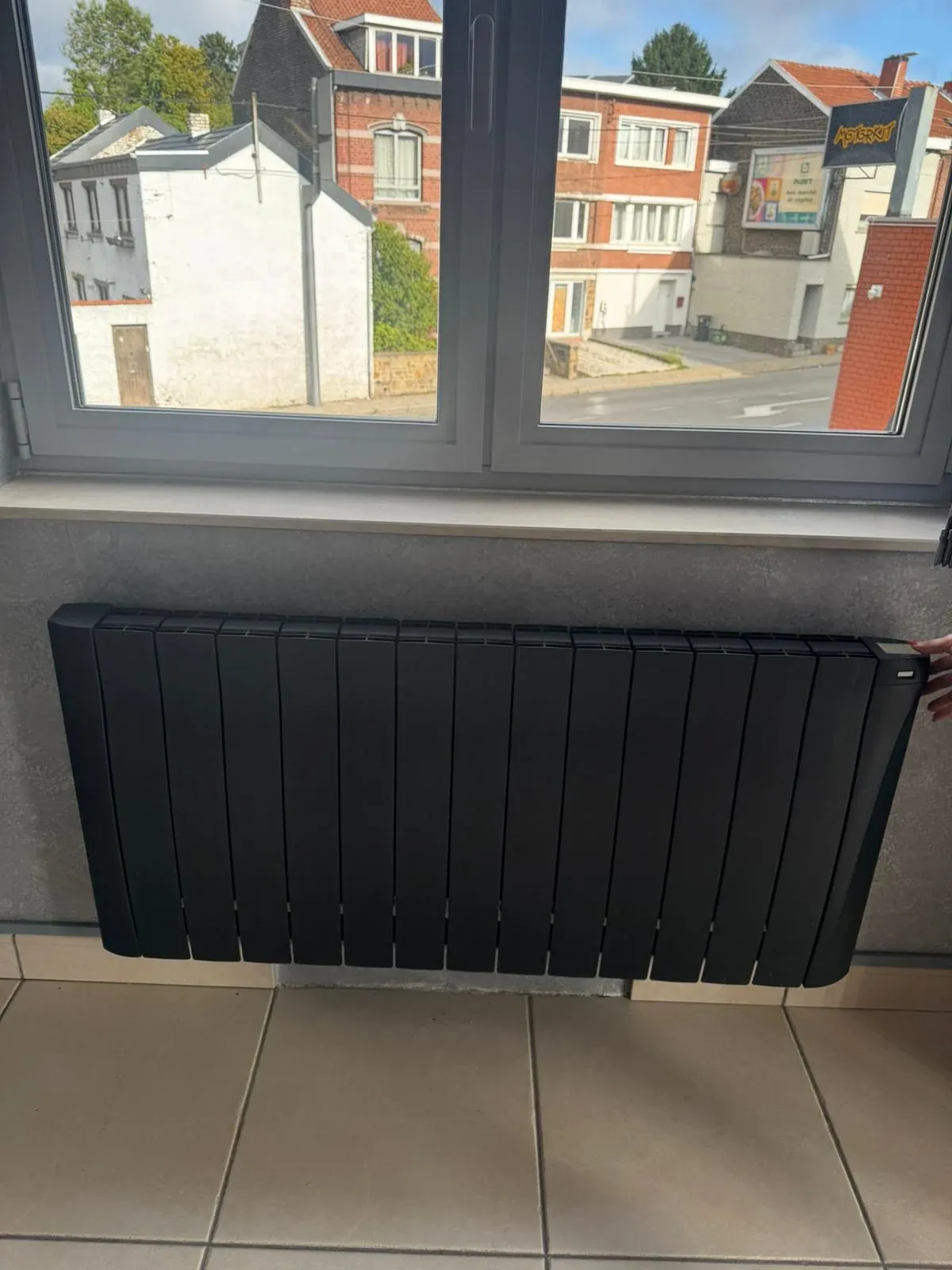 Radiateur anthracite Eco Chaleur installé dans un salon contemporain sous une fenêtre