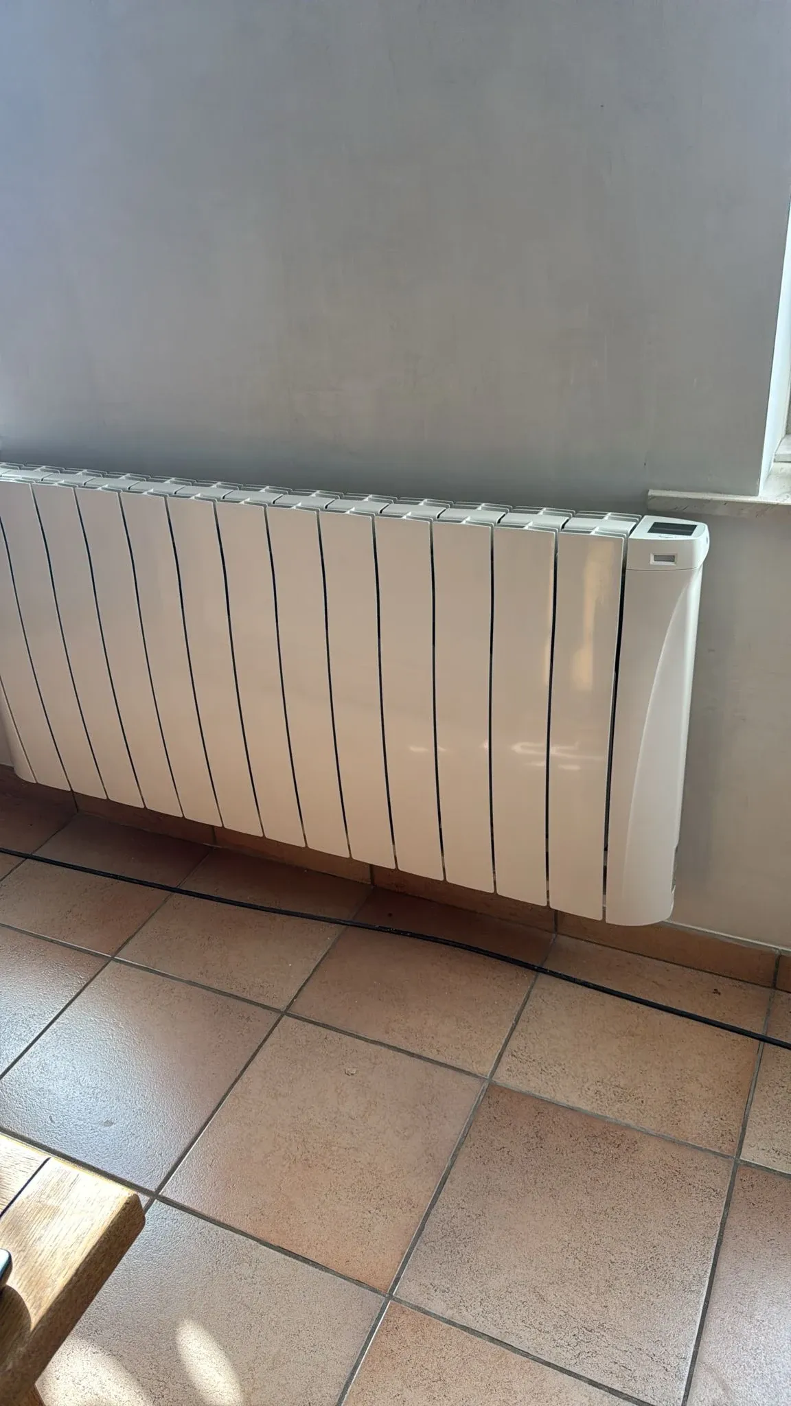 Radiateur Eco Chaleur installé dans une salle à manger au sol carrelé