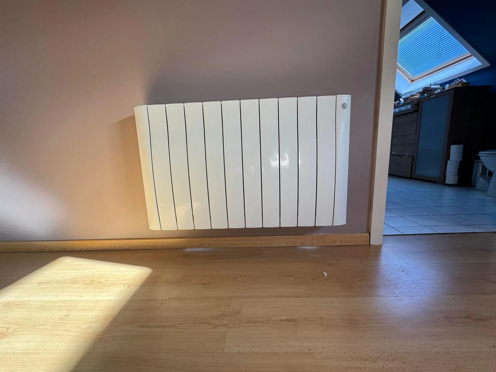 Radiateur Eco Chaleur installé dans une chambre mansardée avec lucarne